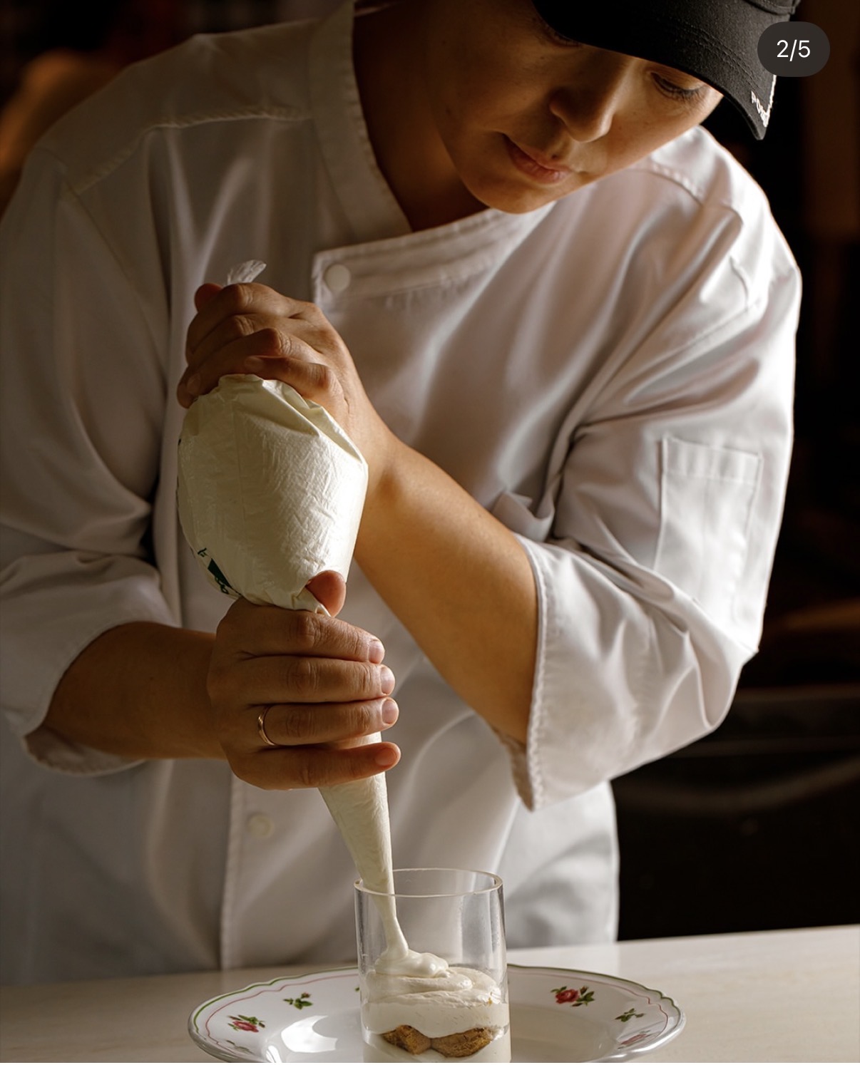 Chef plating a tiramisu dessert for a restaurant shoot